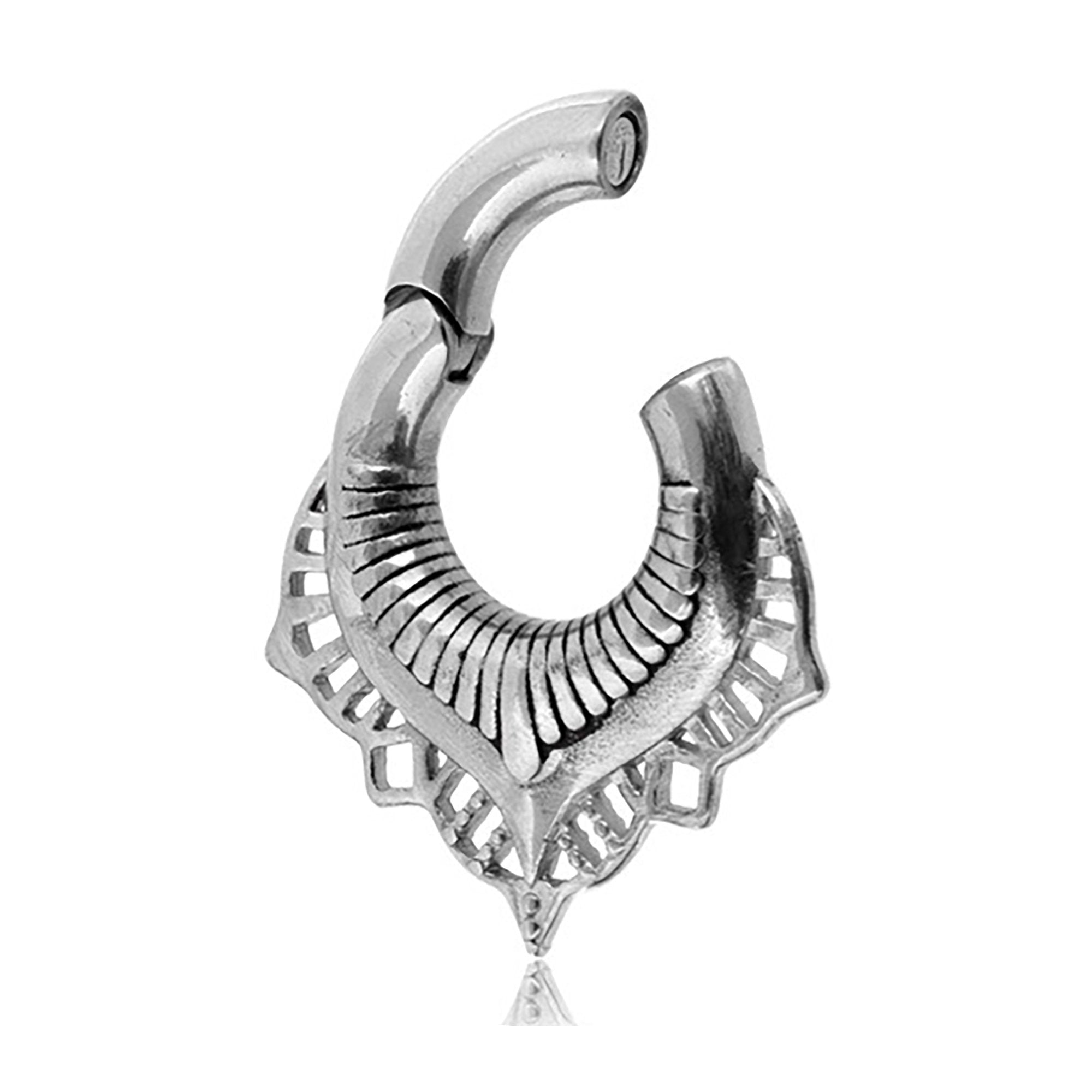 A close-up of the Sacred Lotus Flower Ear Weights in Silver from Kaya Movement. These 2 gauge earrings feature a graceful, crescent-like shape adorned with detailed etchings and cut-out patterns, offering a delicate and elegant aesthetic reminiscent of traditional tribal designs.